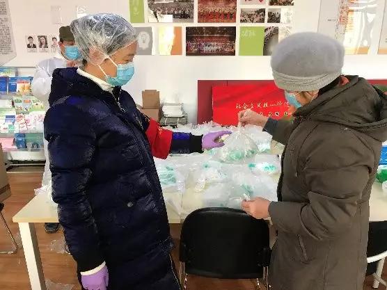 為樓棟分發(fā)口罩，并為包裝袋消毒